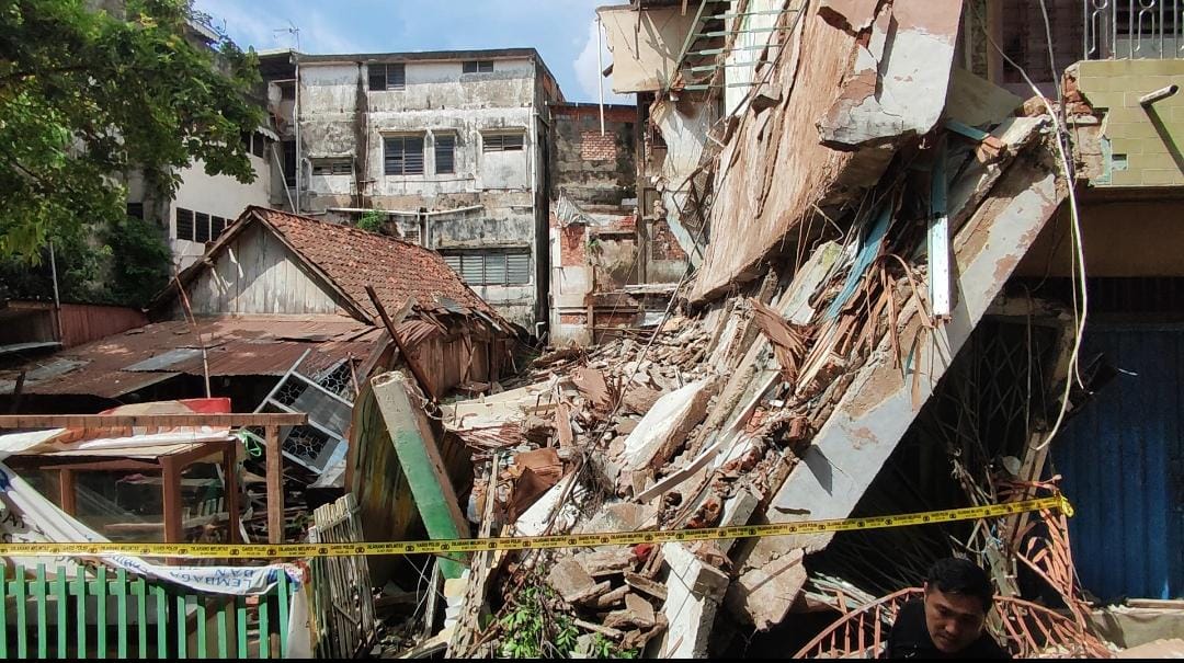 Terdengar Suara Dentuman Keras, Ruko Tiga Lantai Ambruk Menimpa Rumah Tua di Kawasan Megaria Palembang.