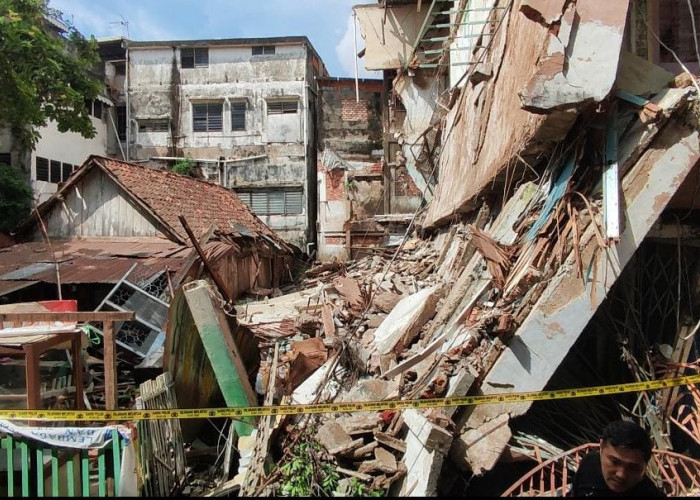 Terdengar Suara Dentuman Keras, Ruko Tiga Lantai Ambruk Menimpa Rumah Tua di Kawasan Megaria Palembang.